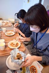 ピザソースを塗った生地に焼いたゆめせんかをトッピングする参加親子