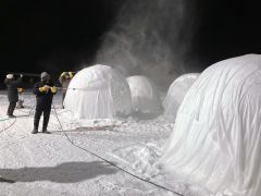 雪が舞う中、バルーンマンションづくりを体験するＡＮＡあきんど札幌支店の社員たち