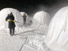 雪が舞う中、バルーンマンションづくりを体験するＡＮＡあきんど札幌支店の社員たち