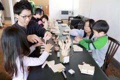 子どもたちにリーの作り方を教える橋本さん（左）、右奥が中島さん