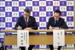 災害時の生活用水提供の協定書に署名する十勝浦幌森永乳業の小森社長と井上町長（左から）