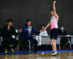 【女子シングルス決勝】相手の羽根がアウトになって決着、優勝を決めてガッツポーズを見せる帯大谷の石原綾弓。左は前主将の江口碧と入江優喜監督