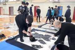 ジャンボ書道に挑戦する児童と八重樫さん（右）