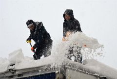物置の除雪に追われる市民（２３日午前８時ごろ、須貝拓也撮影）