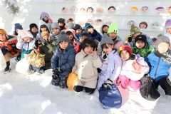 氷のお面と記念撮影する児童(24日午前9時45分ごろ、平栗玲香通信員撮影)