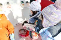 氷のお面を並べる児童(24日午前940分ごろ、平栗玲香通信員撮影)