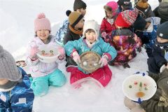 氷のお面を見せる児童(24日午前9時半ごろ、平栗玲香通信員撮影)