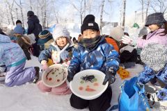 氷のお面を見せる児童(24日午前9時半ごろ、平栗玲香通信員撮影)