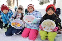 氷で作ったお面を見せる児童ら(24日午前10時ごろ)