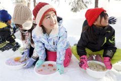 氷のお面を洗面器から取り出す児童(24日午前10時ごろ、平栗玲香通信員撮影)