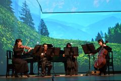 美しいプロジェクションマッピングが映し出された舞台で演奏する弦楽四重奏
