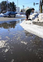 歩道の雪を崩す付近住民（３０日正午ごろ。市内西６南１９で。金野和彦撮影）