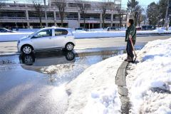 気温が上がり、車道に水たまりができた（３０日正午ごろ。市内西６南１９で。金野和彦撮影）