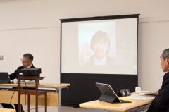 オンラインで出席した本間氏（スクリーン）