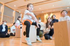 音楽に合わせて打楽器「カホン」を叩く園児たち
