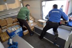 貨物の積み降ろし用に設けた開口部を開け、貨物を下ろす関係者（７日午前９時ごろ、十勝バス広尾営業所で）