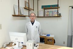 レトロな雰囲気な内装にしたという岩浪佳晃さん。薬局内にはお菓子のラムネも常備。「お一つどうぞ」と手渡してくれる。店長は代表夫妻が飼っているワンちゃん・てんちゃん（８）。