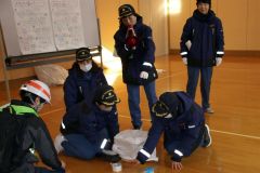 携帯トイレの使い方を実演する女性消防団員