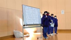 携帯トイレの使い方を実演する女性消防団員