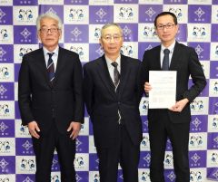 答申書を手にする井上町長（右）と答申した上村会長（中央）。左は山岸副会長