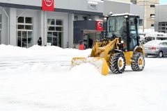 除雪に追われる帯広日産ドーム店の従業員（１６日、午前９時ごろ、市内西７南２０で。金野和彦撮影）