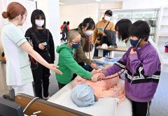 ダミー人形に聴診器を当て、医療体験をする参加者（１７日、午前１１時５０分ごろ、金野和彦撮影）