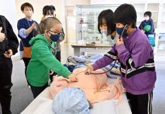 ダミー人形に聴診器を当て、医療体験をする参加者（１７日、午前１１時５０分ごろ、金野和彦撮影）
