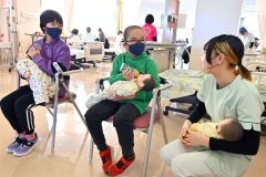 赤ちゃんの抱き方や授乳体験をする子ども（１７日、午前１１時ごろ、金野和彦撮影）