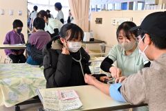 保護者の血圧を測る体験をする子ども（１７日、午前１１時ごろ、金野和彦撮影）