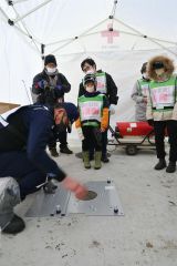 マンホールトイレの設置を見学する参加者ら（１７日午後２時４５分ごろ、下音更中学校敷地内）