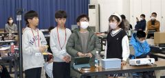 スクリーン越しに講師の山口さんにグループワークの成果を発表する児童ら