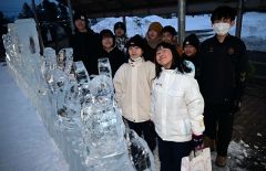氷彫刻の横で笑顔を浮かべる６年生（２１日、須貝拓也撮影）