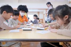 商品が描かれた塗り絵を丁寧に塗る園児ら