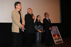 公開初日に舞台あいさつした出演者ら。左から藤監督、中原さん、中川さん、喜井町長(23日午前11時半ごろ、須貝拓也撮影)