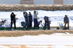 雪解けが進む練習場で、爽快にボールを飛ばすゴルファー(23日午前10時40分ごろ、札内川ゴルフ練習場で。金野和彦撮影)