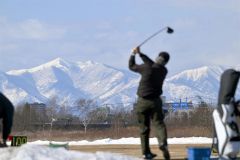 雪解けが進む練習場で、爽快にボールを飛ばすゴルファー(23日午前11時ごろ、札内川ゴルフ練習場で。金野和彦撮影)