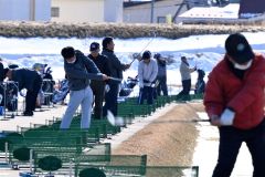 雪解けが進む練習場で、爽快にボールを飛ばすゴルファー(23日午前10時50分ごろ、札内川ゴルフ練習場で。金野和彦撮影)