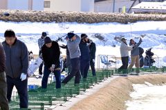 雪解けが進む練習場で、爽快にボールを飛ばすゴルファー(23日午前10時半ごろ、札内川ゴルフ練習場で。金野和彦撮影)