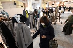 お気に入りの服を手にとって品定めする来場者(24日午前11時半ごろ、須貝拓也撮影)