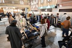 お気に入りの服を品定めする来場者(24日午前11時半ごろ、須貝拓也撮影)