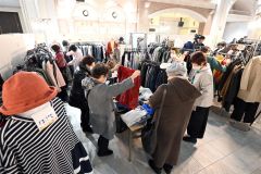お気に入りの服を手にとって品定めする来場者(24日午前11時半ごろ、須貝拓也撮影)