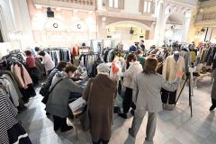 お気に入りの服を手にとって品定めする来場者(24日午前11時半ごろ、須貝拓也撮影)