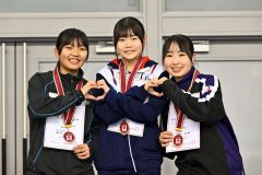 女子５００メートルの表彰台で満面の笑みでポーズを取る（左から）２位の奥秋静子（帯三条）、優勝の笹渕和花（帯南商）、３位の石岡文那（山縣中央）＝金野和彦撮影）
