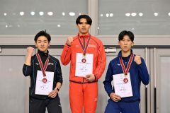 男子５００メートルの表彰台でガッツポーズをする（左から）２位の佐藤敦（帯三条）、優勝の軍司冬馬（白樺学園）、３位の阿部春琉斗（駒大苫小牧）＝金野和彦撮影
