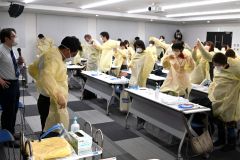 医療関係者らの「感染症対応力向上研修」でＰＰＥの着脱を確認する参加者。新型コロナの教訓を新たな変異株出現や感染症対策につなげようと努めている（２０日、帯広市内）