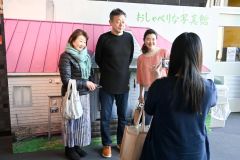 藤監督と写真館のパネル前で記念撮影する来館者