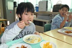 ホタテをぜいたくに使ったスパゲティを頬張る児童