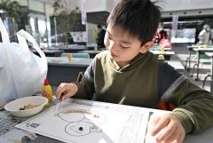 豆の貼り絵を楽しむ子ども(3日午前10時ごろ、須貝拓也撮影)