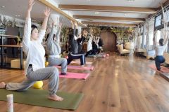 十勝平野を眺めながらヨガで体をほぐす参加者