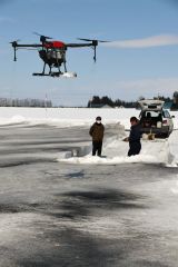 墨汁融雪剤を農場に散布するドローン